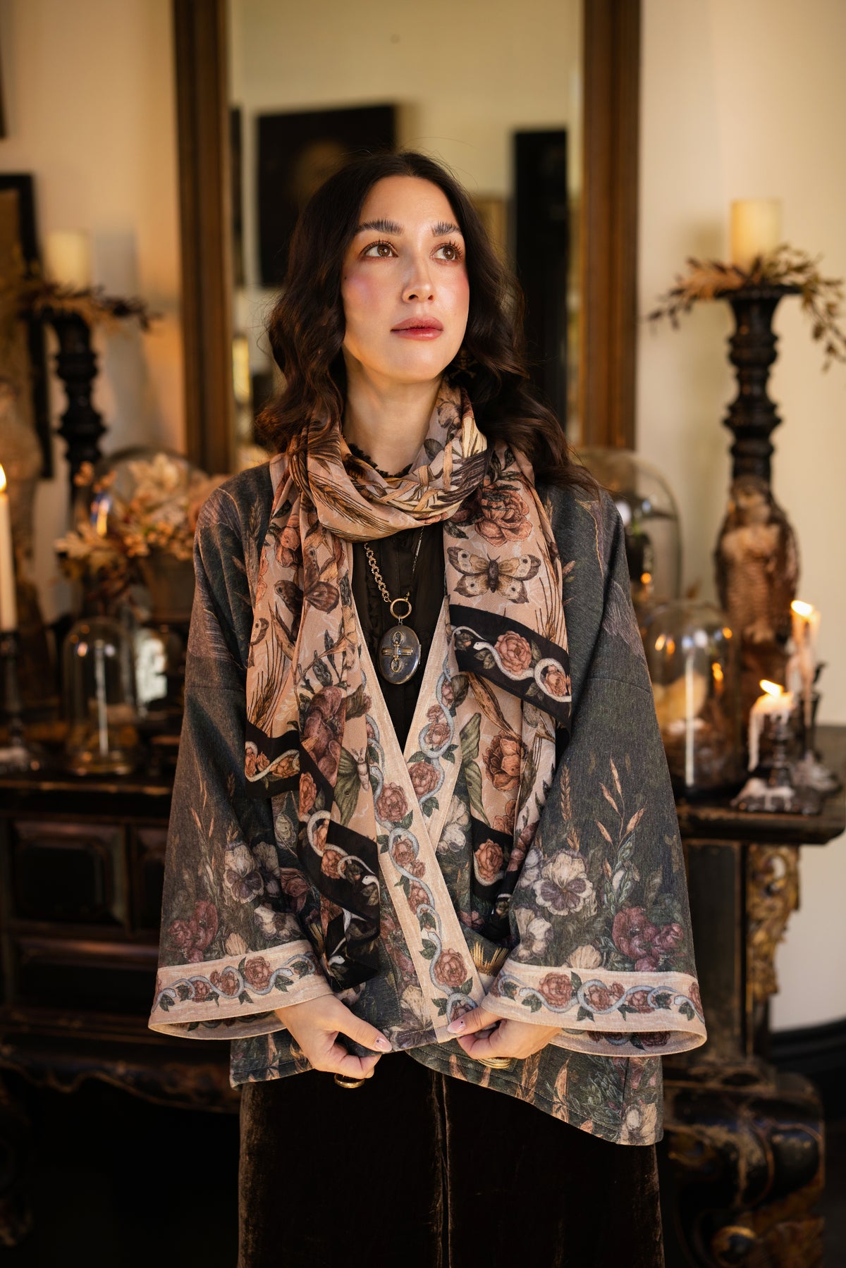 Model wearing a cozy fleece lined cottage cardigan ft. artwork created by Jessica Roux including two starlings beneath a full moon with flowers, butterflies, moths and botanical artwork - Market of Stars