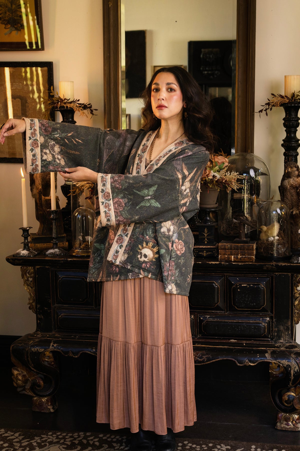 Model wearing a cozy fleece lined cottage cardigan ft. artwork created by Jessica Roux including two starlings beneath a full moon with flowers, butterflies, moths and botanical artwork - Market of Stars