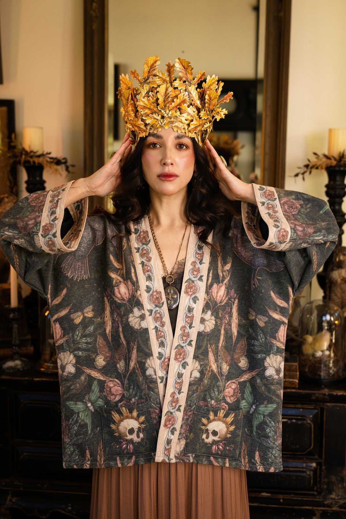Model wearing a cozy fleece lined cottage cardigan ft. artwork created by Jessica Roux including two starlings beneath a full moon with flowers, butterflies, moths and botanical artwork - Market of Stars
