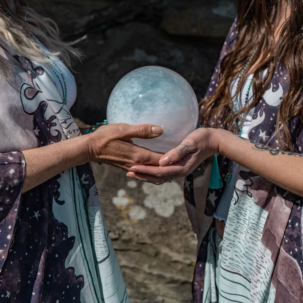 
                  
                    Model wearing Moonstruck Goddess Duster featuring original artwork by Leslie Love, inspired by the ocean, the night sky, and the artist’s handmade botanical inks – Market of Stars.
                  
                