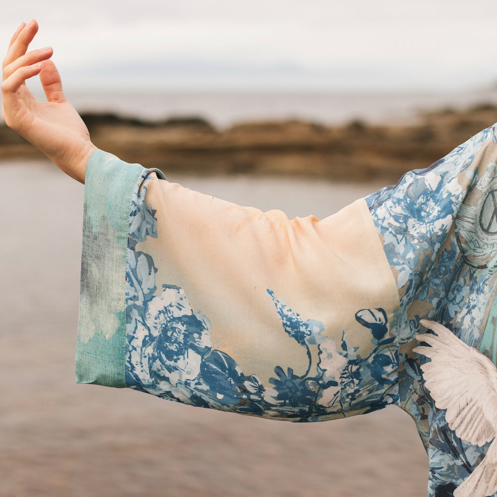 
                  
                    Model wearing our Peace Out Pixie Duster featuring 1800's perfumeur sign with gentle tones of blue & aqua, landscapes, clouds, dove and peace symbols -Market of Stars.
                  
                