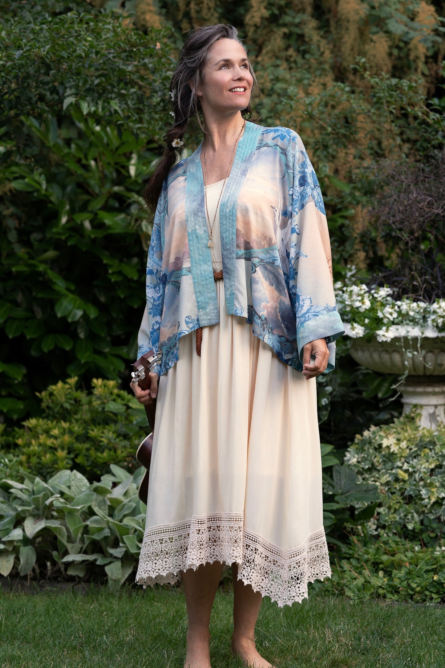 Model wearing our Peace Out Pixie Duster featuring 1800's perfumeur sign with gentle tones of blue & aqua, landscapes, clouds, dove and peace symbols -Market of Stars.