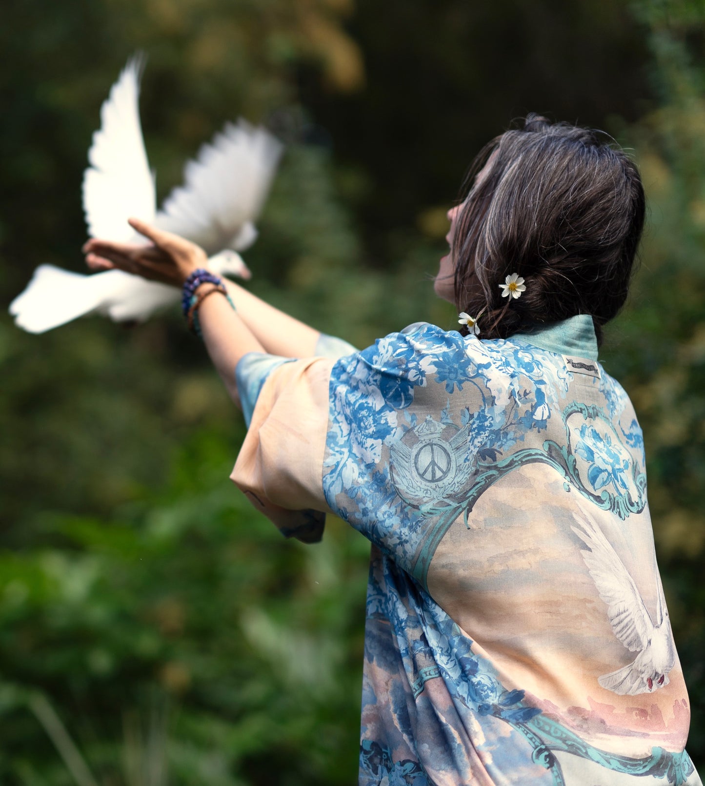 Model wearing our Peace Out Pixie Duster featuring 1800's perfumeur sign with gentle tones of blue & aqua, landscapes, clouds, dove and peace symbols -Market of Stars.