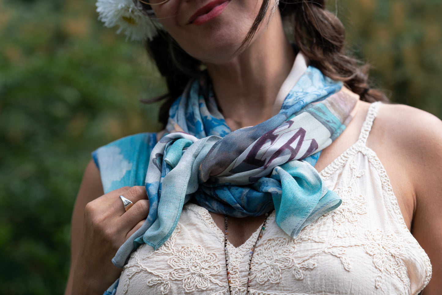 Model wearing our Peace Out scarf featuring 1800's perfumeur sign with gentle tones of blue & aqua, landscapes, clouds, dove, and peace symbols -Market of Stars