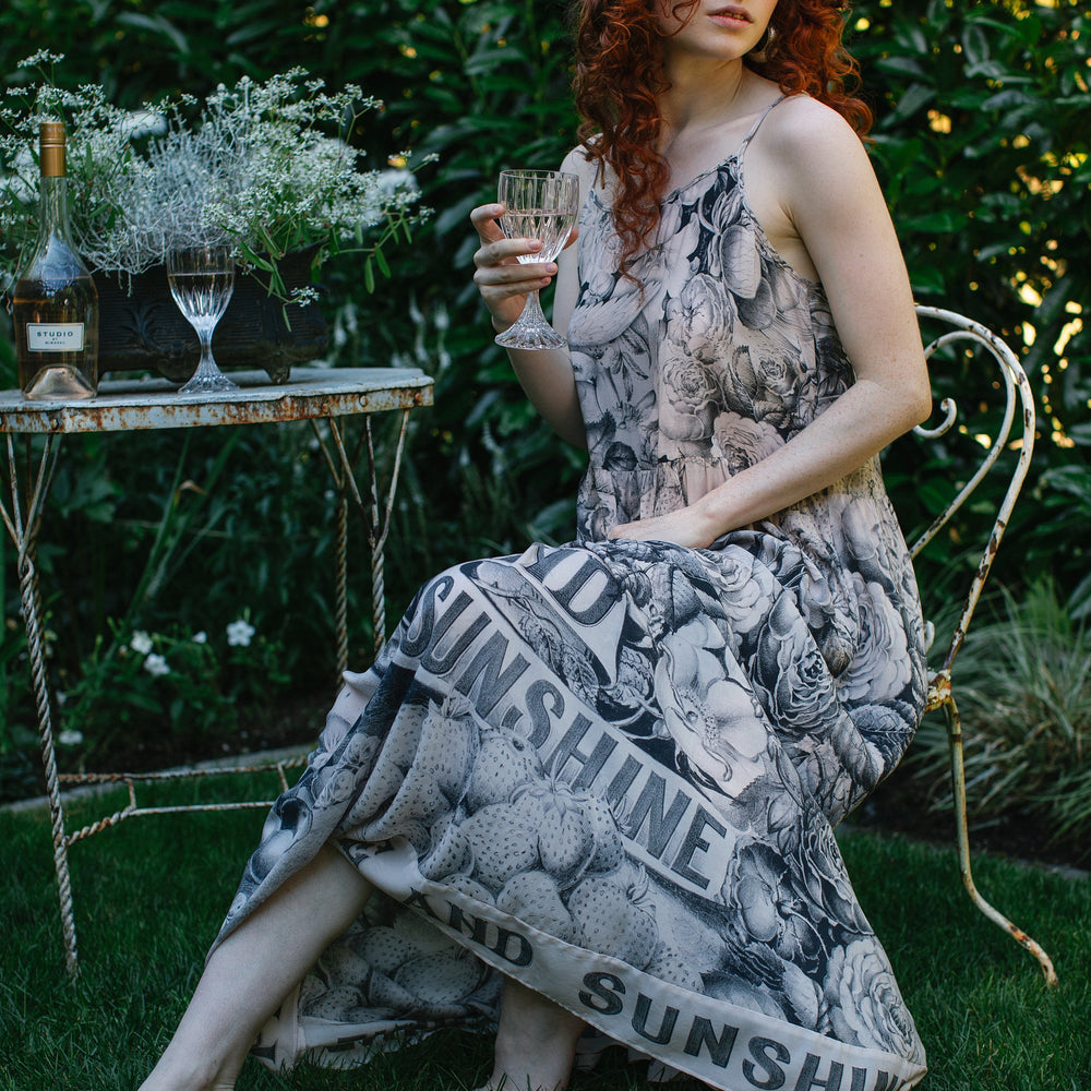 Model wearing Peace, Wine & Sunshine Bohéme Slip Dress featuring botanical collages and playful peace, wine and sunshine lettering on the hem – Market of Stars.