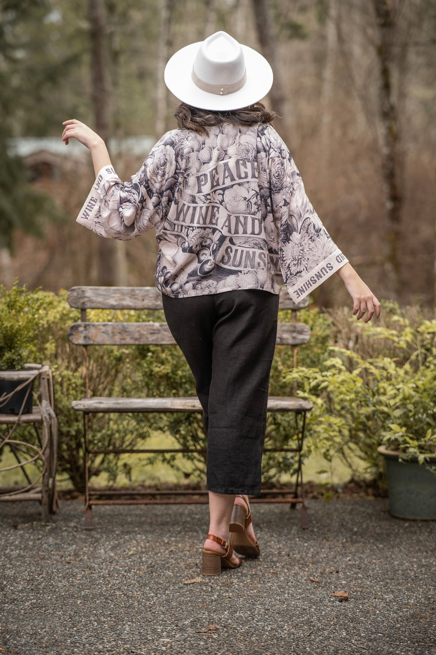 Model wearing Peace, Wine & Sunshine Bohéme Slip Dress featuring botanical collages and playful peace, wine and sunshine lettering on the hem – Market of Stars.