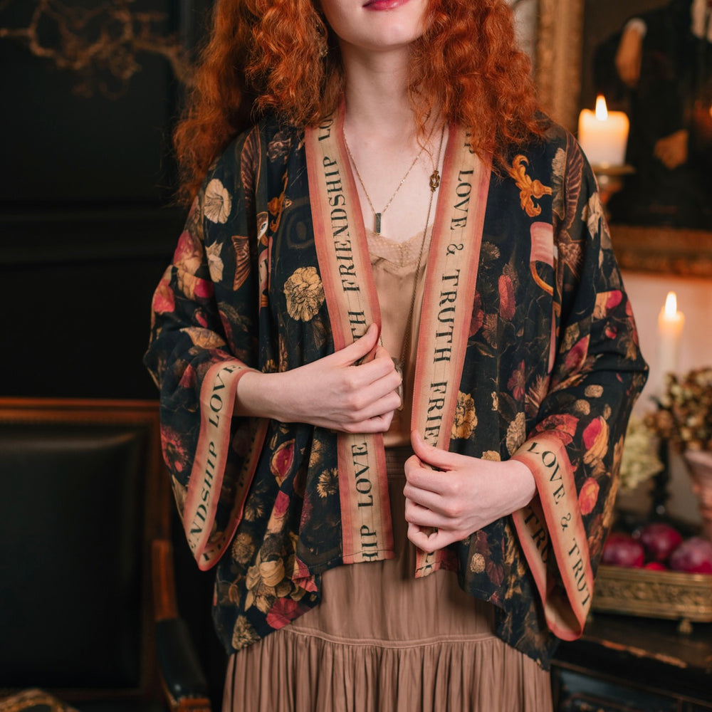 
                  
                    Model wearing a cropped-length bamboo-viscose duster featuring a collage of antique artwork with romance, loyalty, and old-world beauty - Market of Stars
                  
                