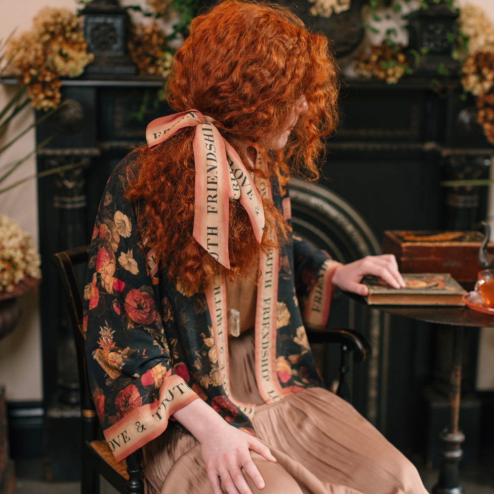 
                  
                    Model wearing a cropped-length bamboo-viscose duster featuring a collage of antique artwork with romance, loyalty, and old-world beauty - Market of Stars
                  
                