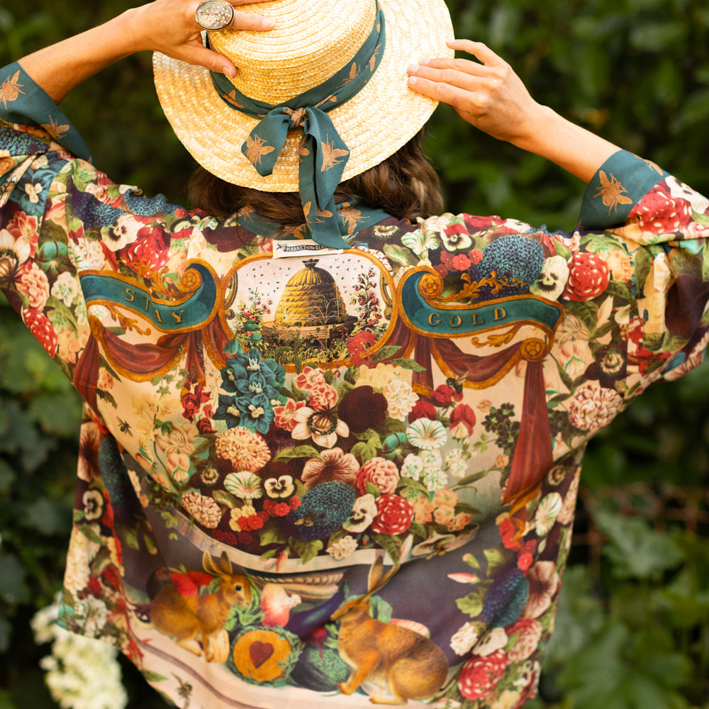Model wearing Stay Gold Pixie Duster featuring wildflowers, bees, bunny rabbits and poetic vintage collage in cropped length – Market of Stars
