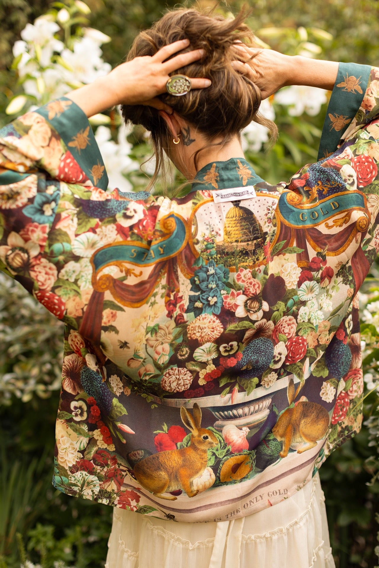 Model wearing Stay Gold Pixie Duster featuring wildflowers, bees, bunny rabbits and poetic vintage collage in cropped length – Market of Stars