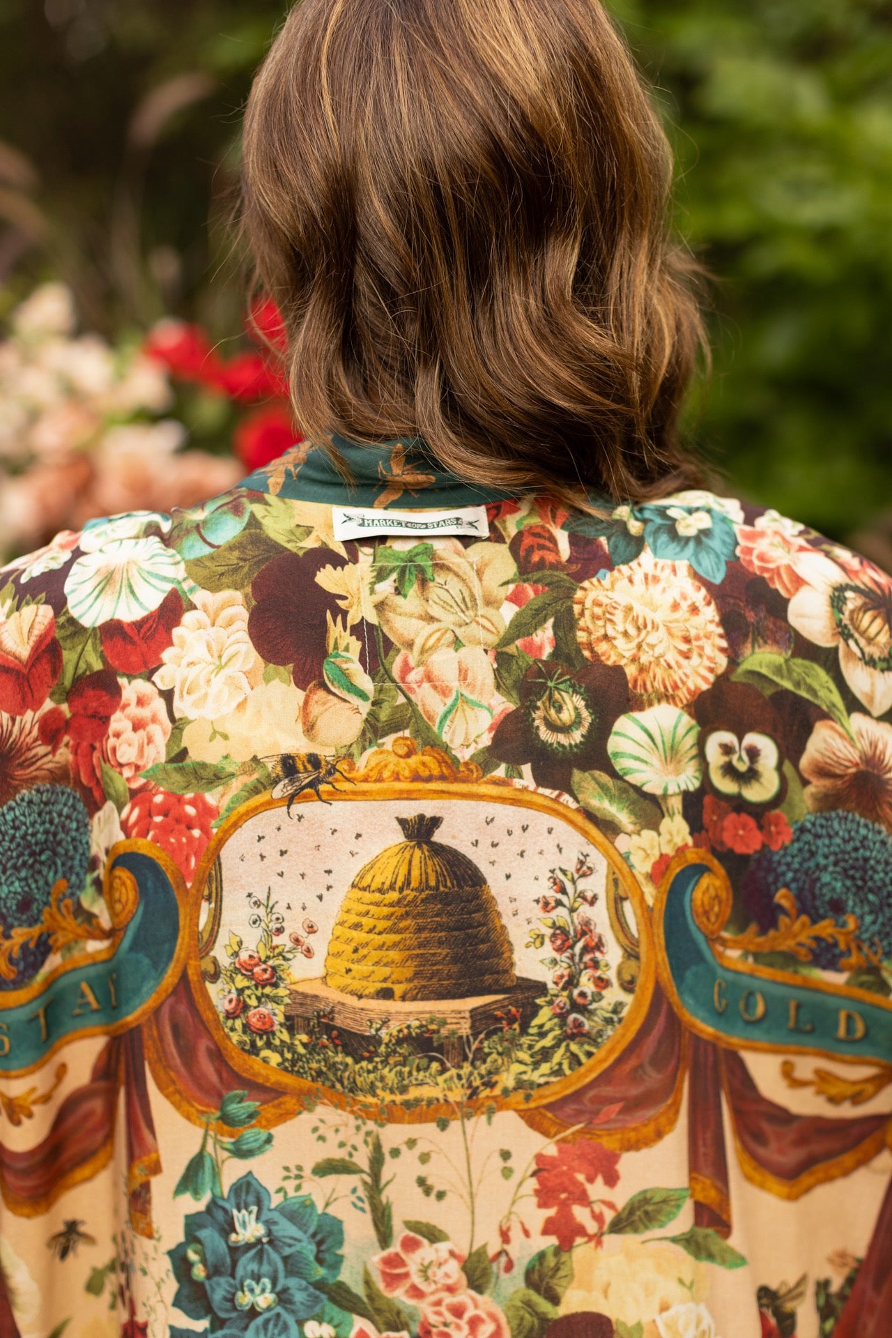 Model wearing Stay Gold Pixie Duster featuring wildflowers, bees, bunny rabbits and poetic vintage collage in cropped length – Market of Stars