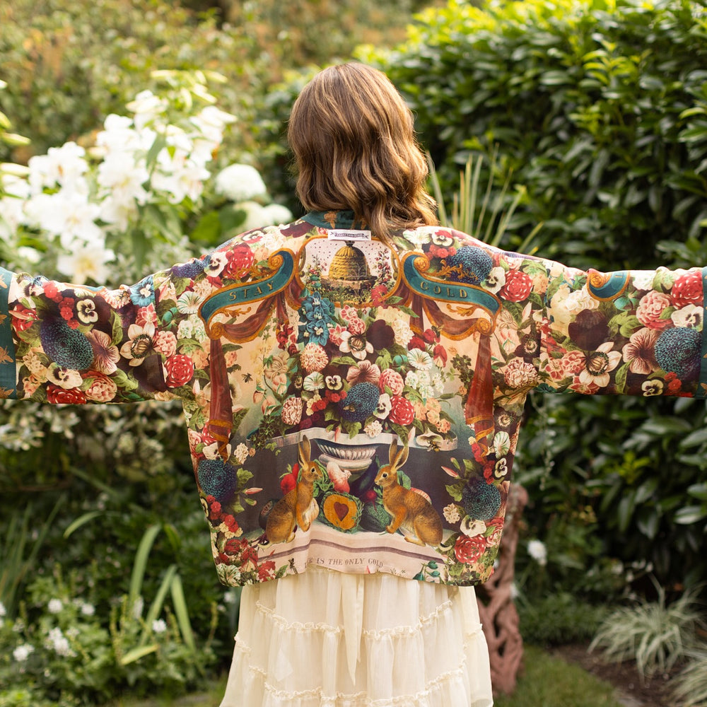 
                  
                    Model wearing Stay Gold Pixie Duster featuring wildflowers, bees, bunny rabbits and poetic vintage collage in cropped length – Market of Stars
                  
                