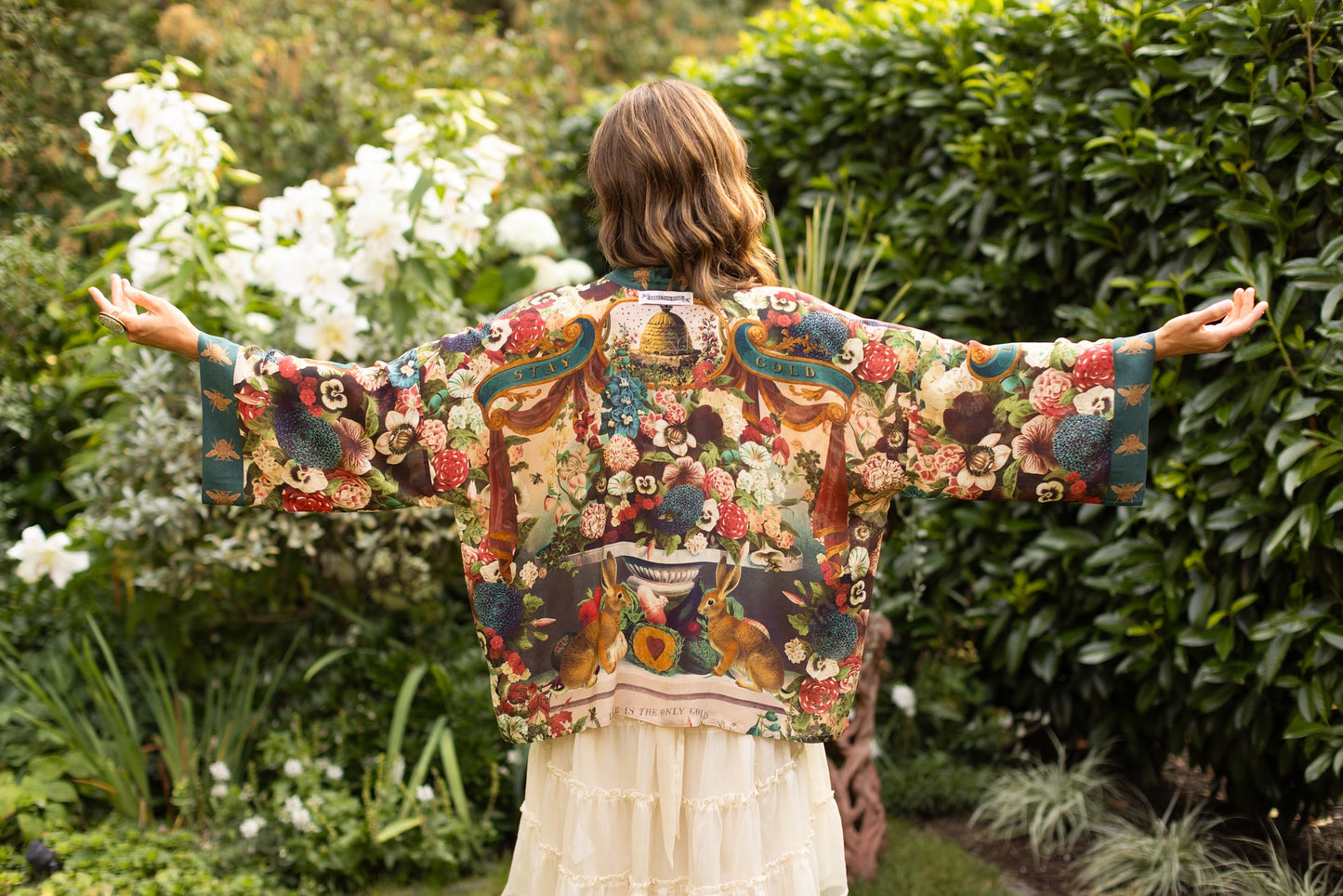 Model wearing Stay Gold Pixie Duster featuring wildflowers, bees, bunny rabbits and poetic vintage collage in cropped length – Market of Stars