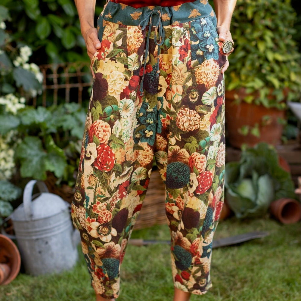 
                  
                    Model wearing Stay Gold linen Artist Pants with lantern hem and floral collage featuring vintage wildflower, bee, and rabbit illustrations – Market of Stars
                  
                