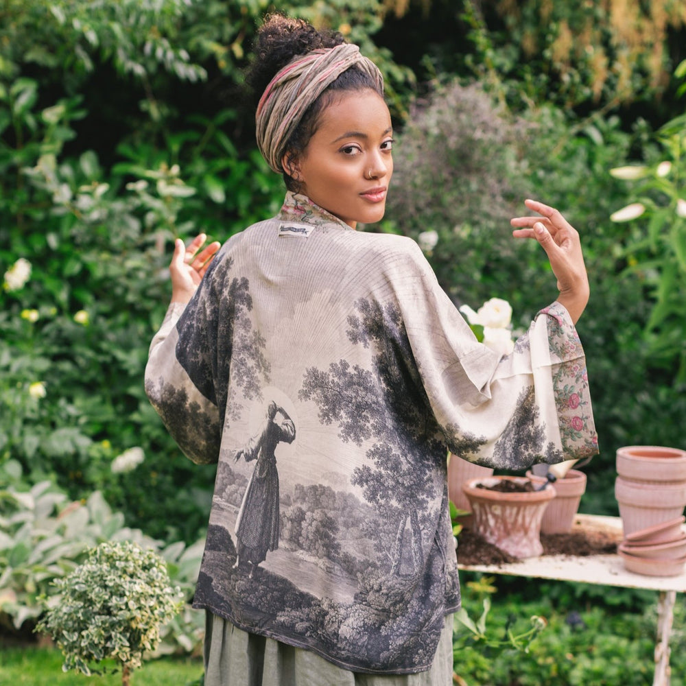 Model wearing our Still I Rise Pixie Duster with empowering message a bold, layered design featuring antique landscape etchings – Market of Stars