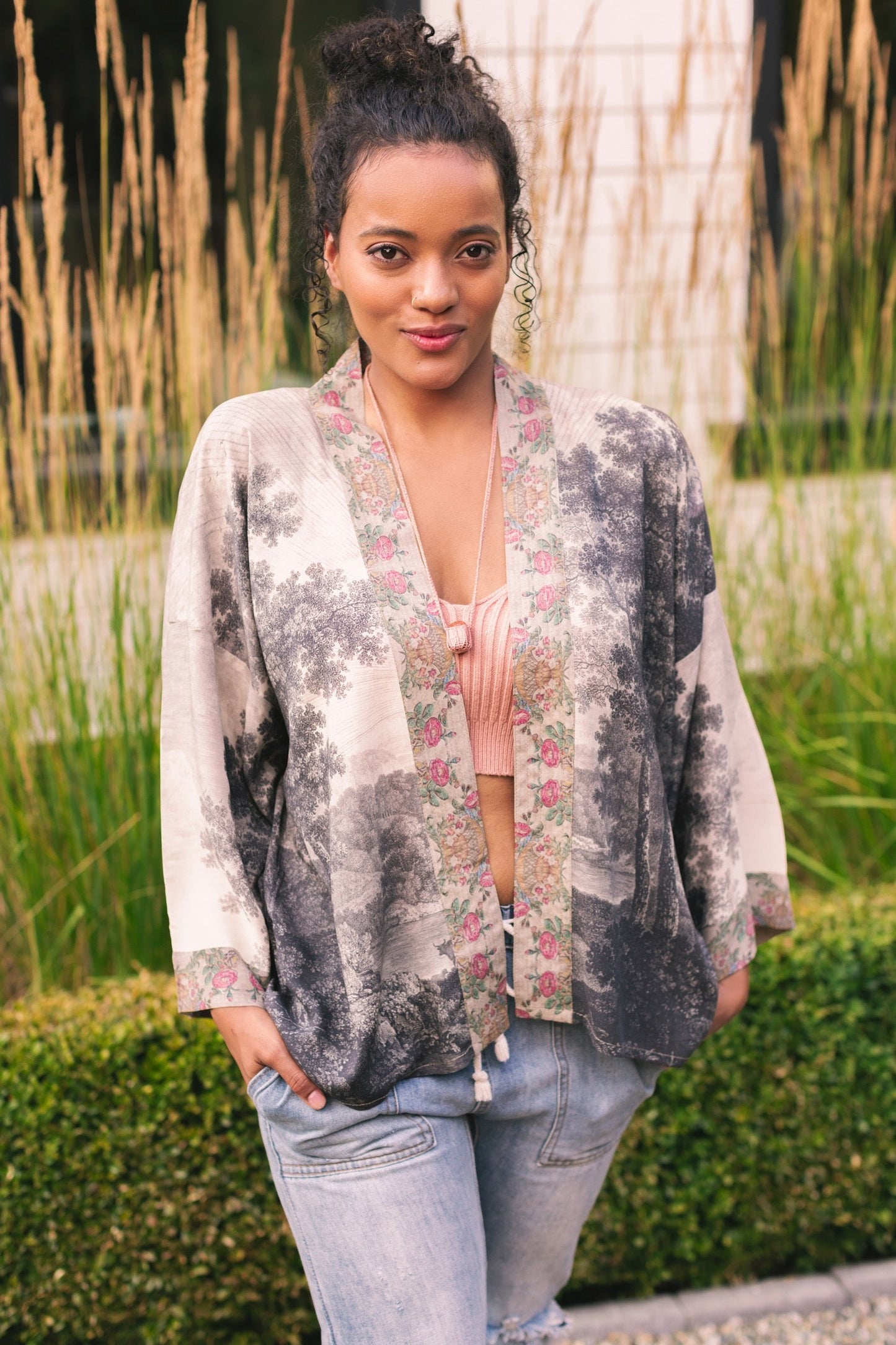 Model wearing our Still I Rise Pixie Duster with empowering message a bold, layered design featuring antique landscape etchings – Market of Stars