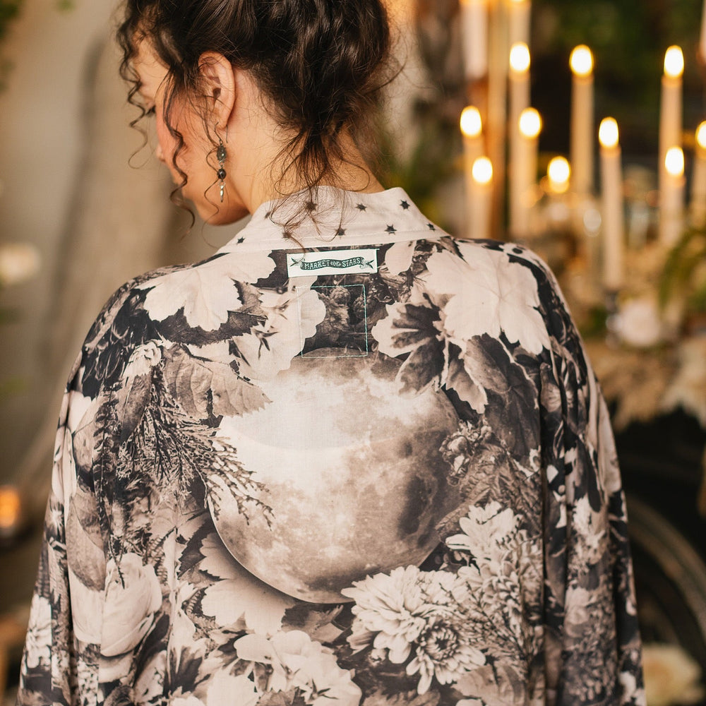 
                  
                    Model wearing Looking Glass Opera Robe featuring grown-up Alice Liddell, Victorian botanicals, and celestial star and moon accents inspired by Wonderland – Market of Stars.
                  
                