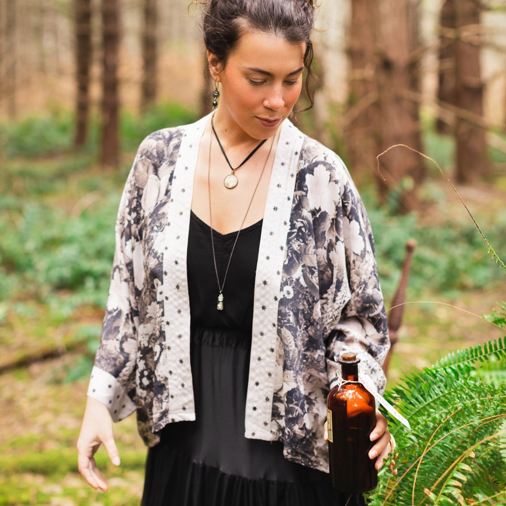 Model wearing Looking Glass Cropped Kimono featuring grown-up Alice Liddell, rare Victorian botanicals, and celestial star and moon accents inspired by Wonderland – Market of Stars.
