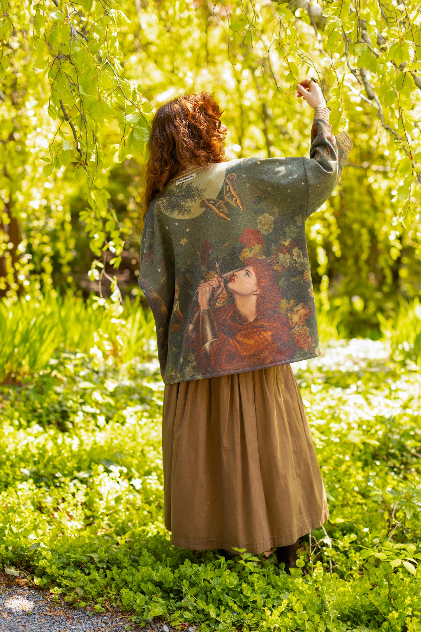 Model wearing a cozy cardigan lined with fleece featuring florals from centuries-old paintings and Rosetti’s iconic portrait of Joan of Arc - Market of Stars