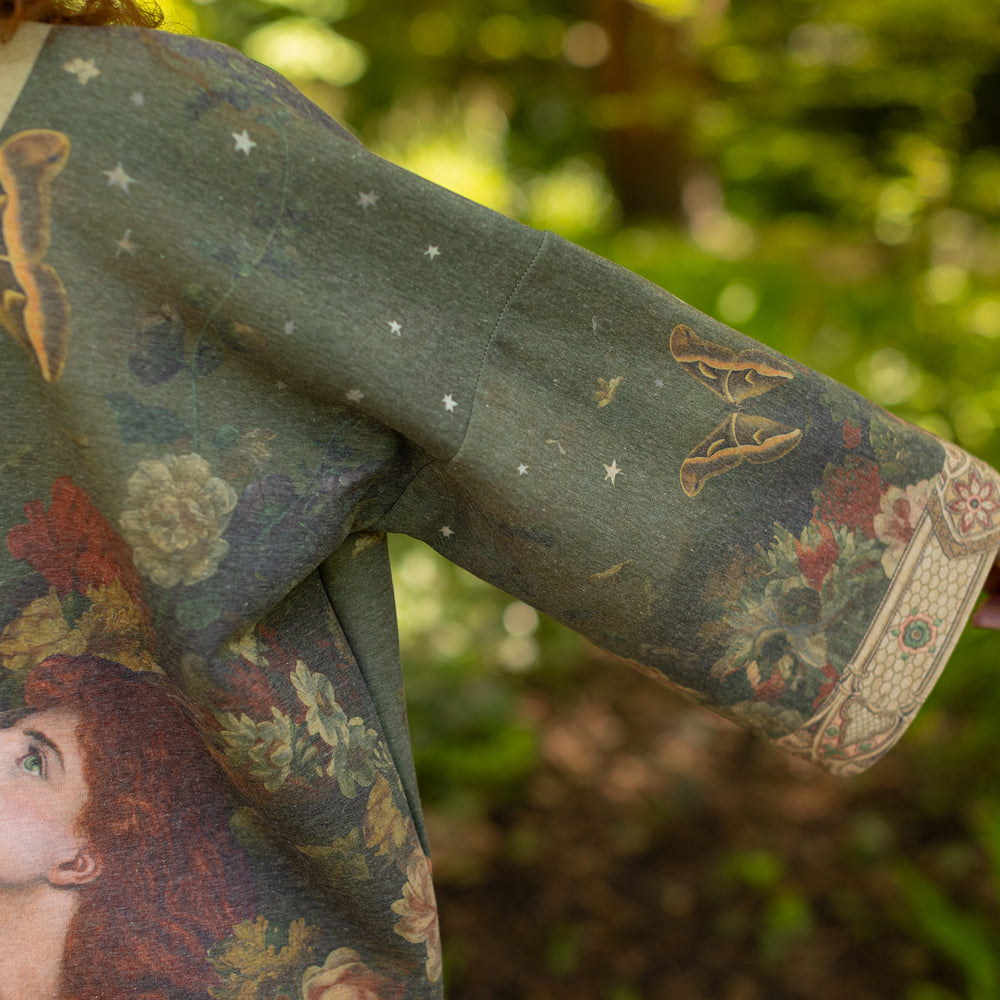 
                  
                    Model wearing a cozy cardigan lined with fleece featuring florals from centuries-old paintings and Rosetti’s iconic portrait of Joan of Arc - Market of Stars
                  
                