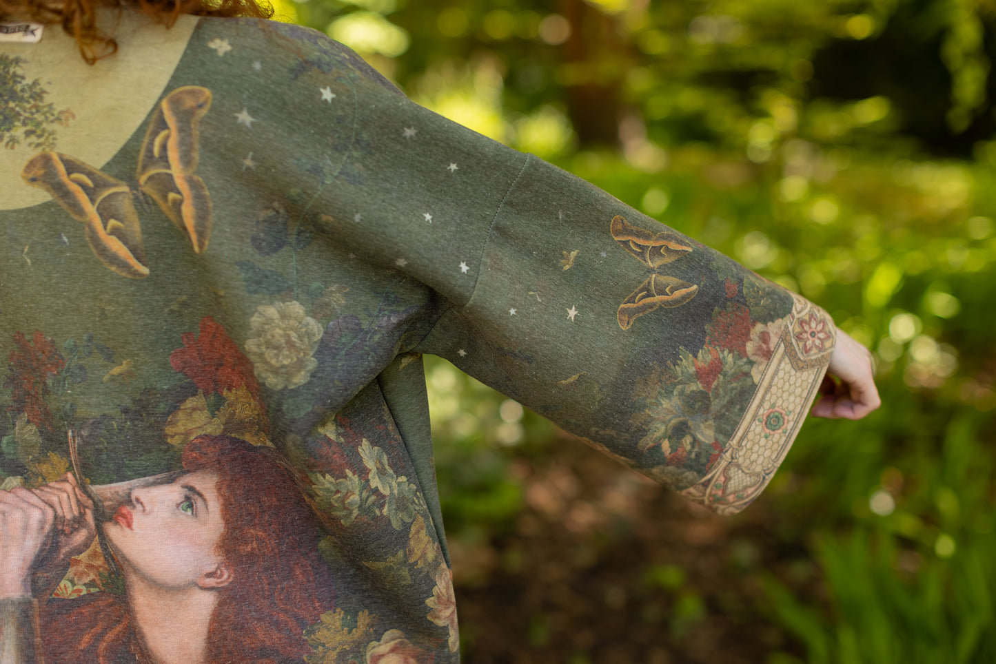 Model wearing a cozy cardigan lined with fleece featuring florals from centuries-old paintings and Rosetti’s iconic portrait of Joan of Arc - Market of Stars