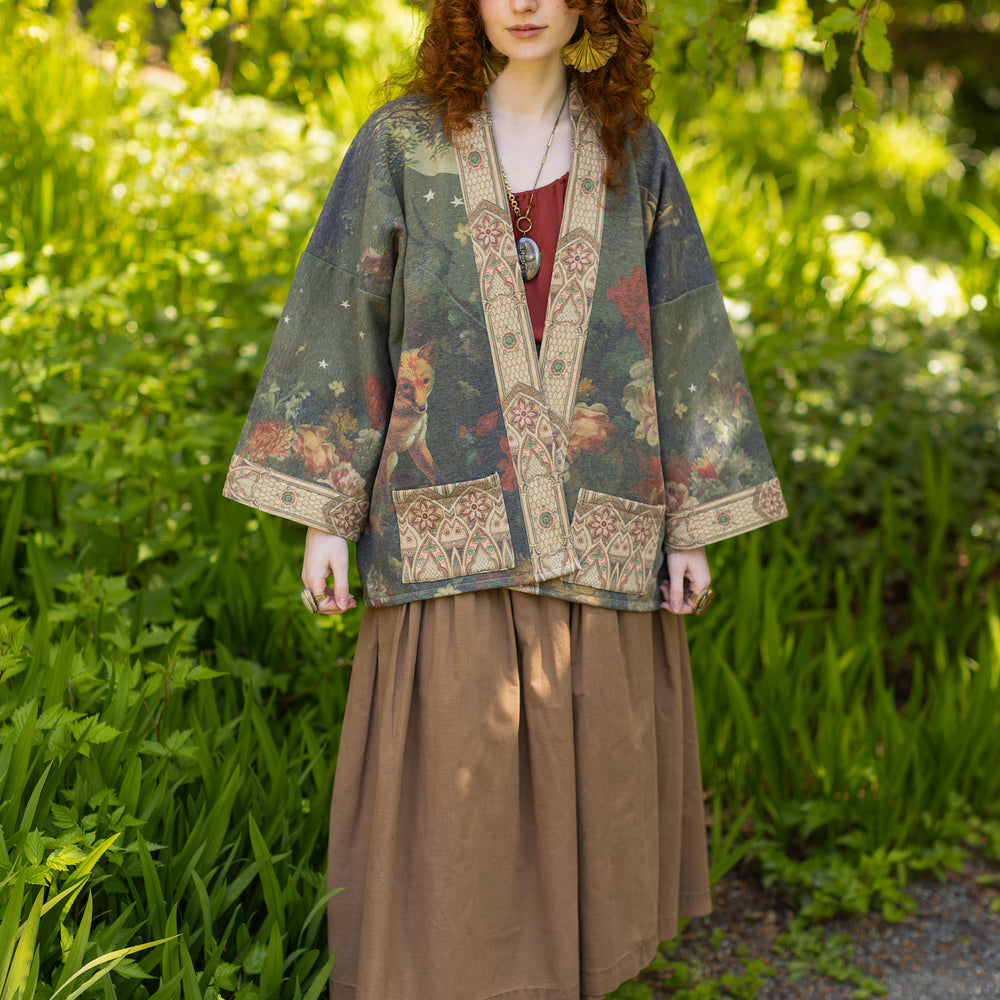 
                  
                    Model wearing a cozy cardigan lined with fleece featuring florals from centuries-old paintings and Rosetti’s iconic portrait of Joan of Arc - Market of Stars
                  
                