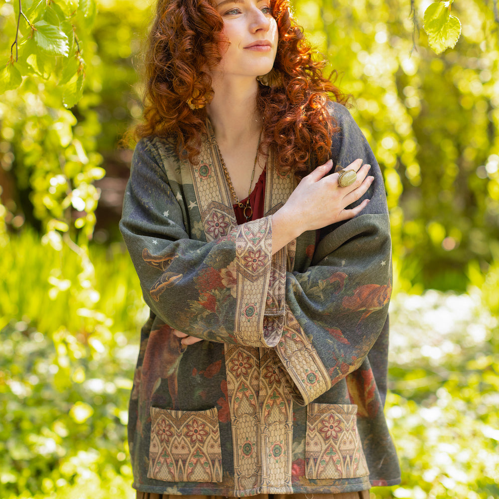 Model wearing a cozy cardigan lined with fleece featuring florals from centuries-old paintings and Rosetti’s iconic portrait of Joan of Arc - Market of Stars