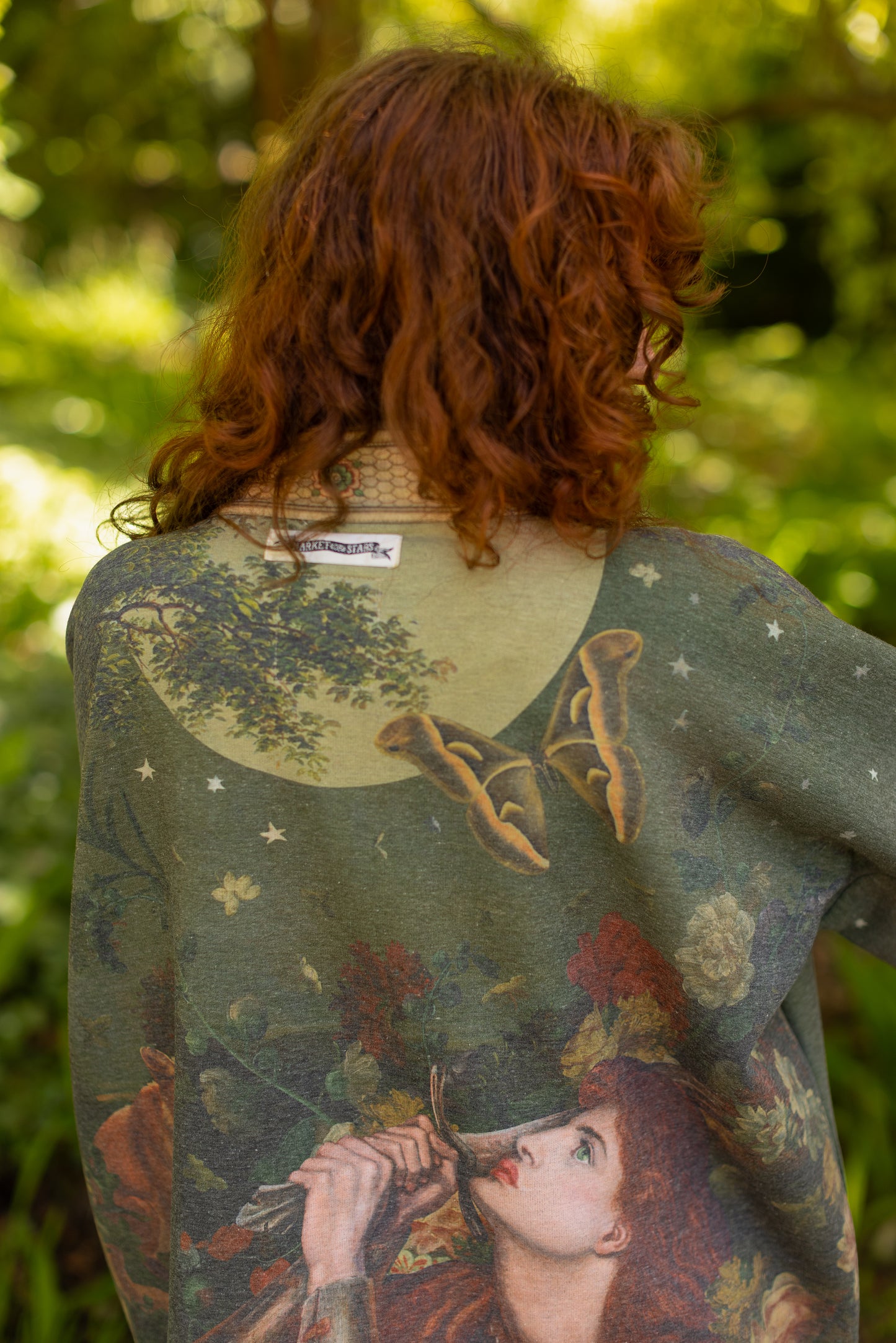 Model wearing a cozy cardigan lined with fleece featuring florals from centuries-old paintings and Rosetti’s iconic portrait of Joan of Arc - Market of Stars