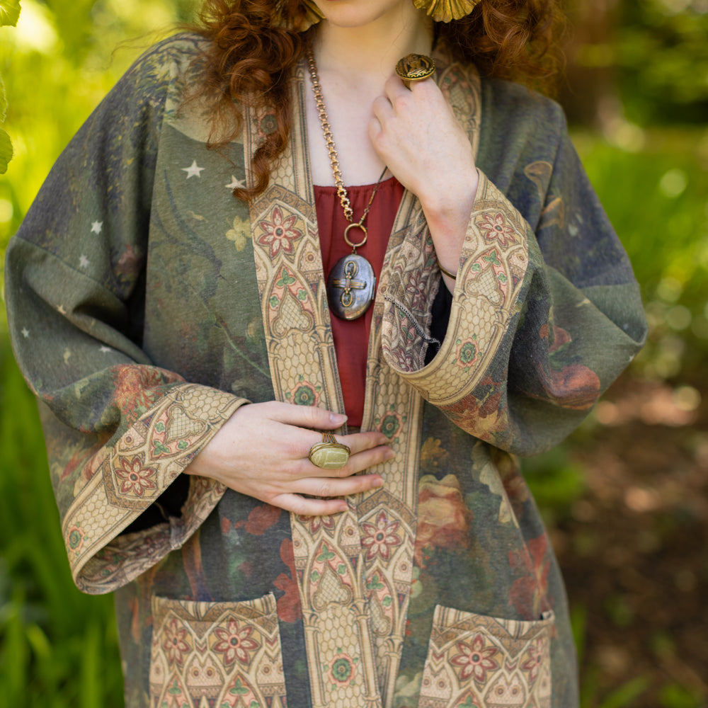 
                  
                    Model wearing a cozy cardigan lined with fleece featuring florals from centuries-old paintings and Rosetti’s iconic portrait of Joan of Arc - Market of Stars
                  
                