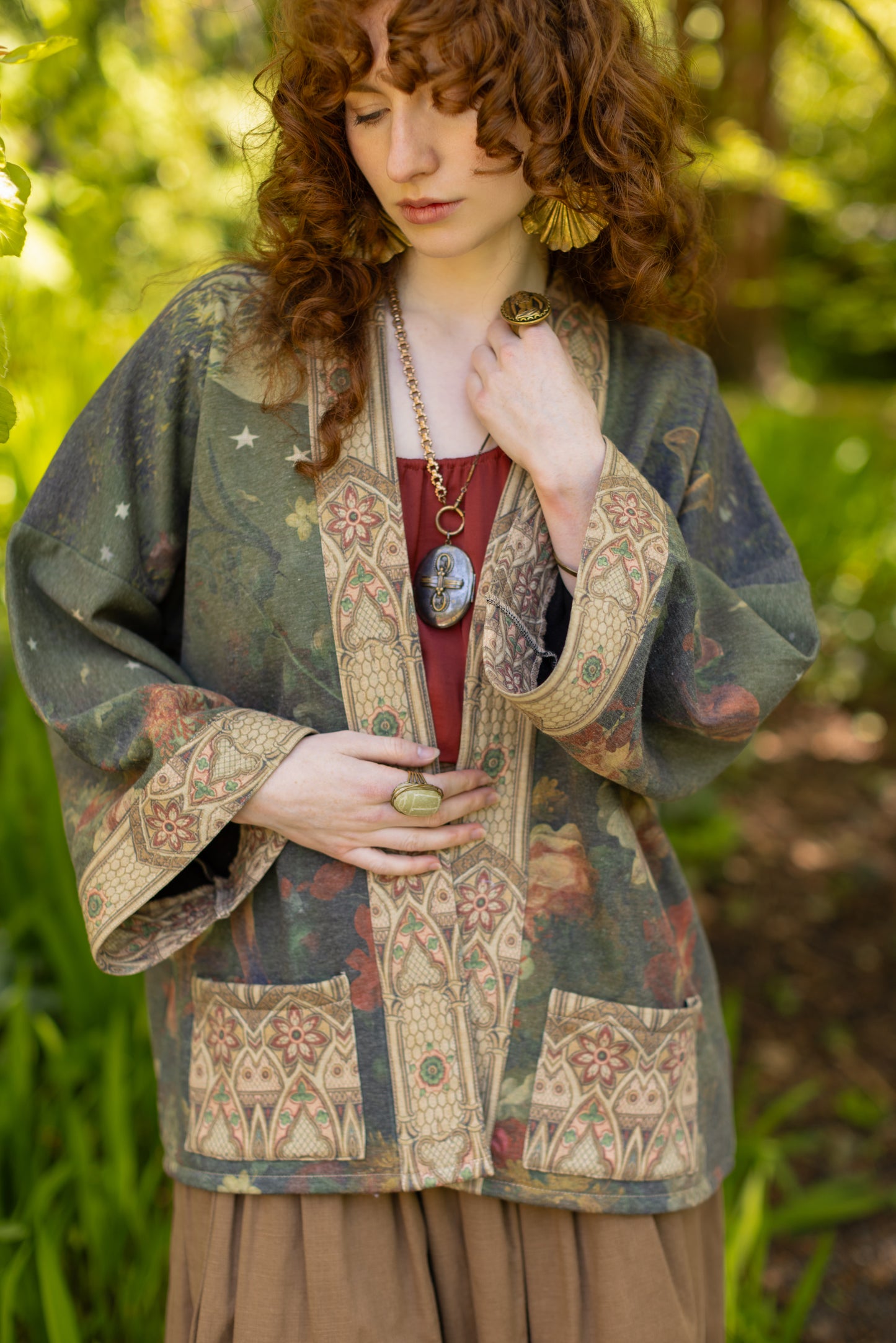 Model wearing a cozy cardigan lined with fleece featuring florals from centuries-old paintings and Rosetti’s iconic portrait of Joan of Arc - Market of Stars