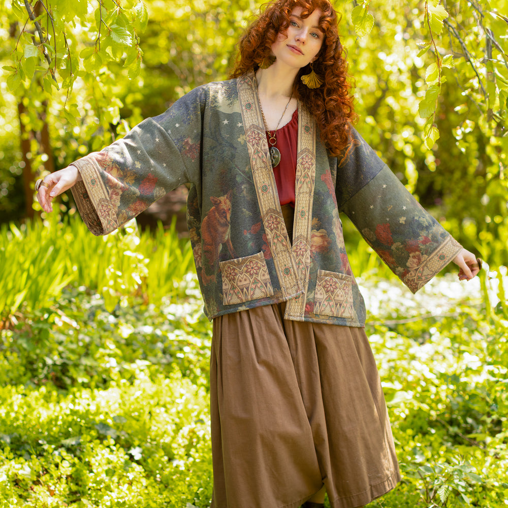 
                  
                    Model wearing a cozy cardigan lined with fleece featuring florals from centuries-old paintings and Rosetti’s iconic portrait of Joan of Arc - Market of Stars
                  
                