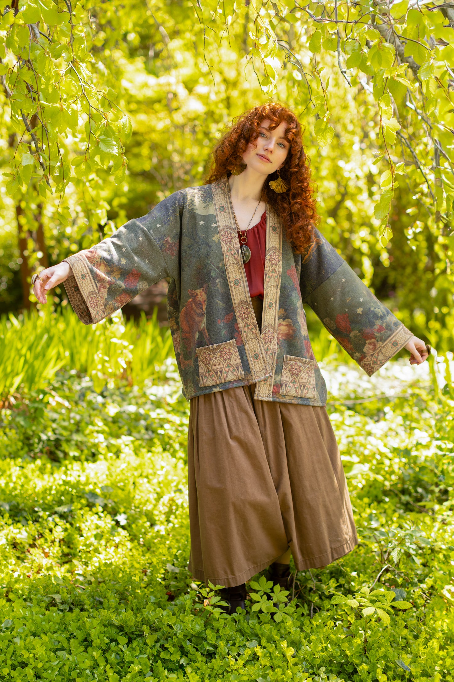 Model wearing a cozy cardigan lined with fleece featuring florals from centuries-old paintings and Rosetti’s iconic portrait of Joan of Arc - Market of Stars