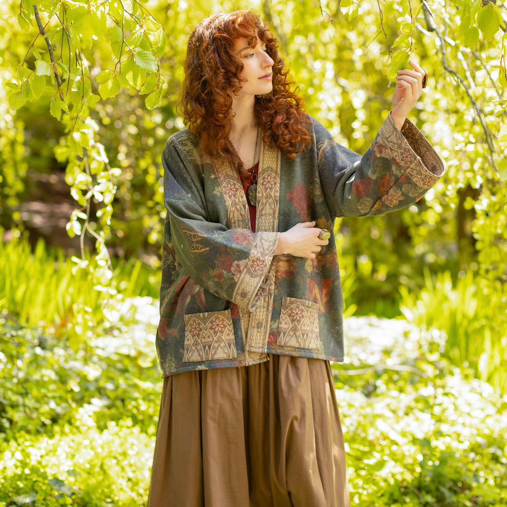 
                  
                    Model wearing a cozy cardigan lined with fleece featuring florals from centuries-old paintings and Rosetti’s iconic portrait of Joan of Arc - Market of Stars
                  
                