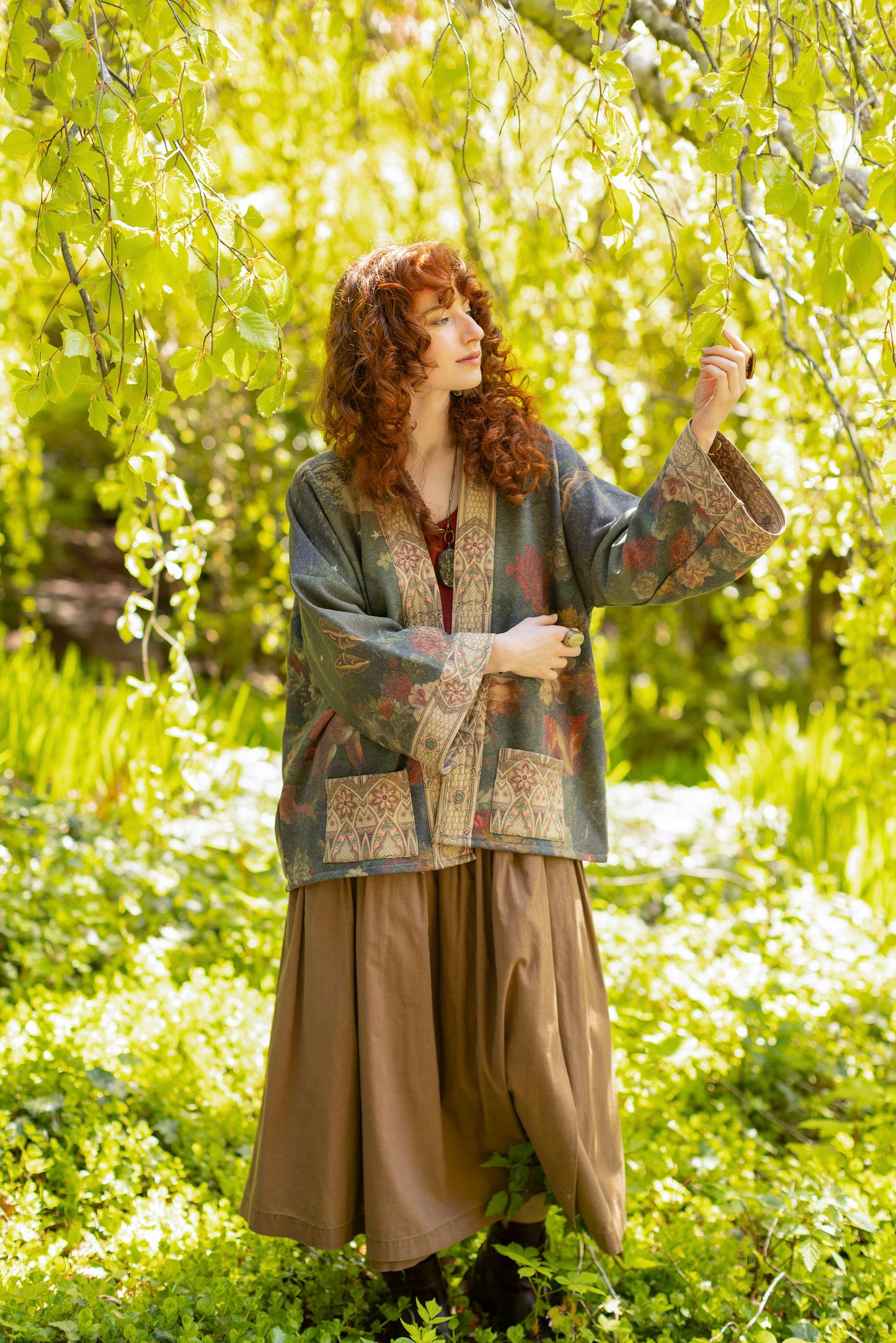 Model wearing a cozy cardigan lined with fleece featuring florals from centuries-old paintings and Rosetti’s iconic portrait of Joan of Arc - Market of Stars