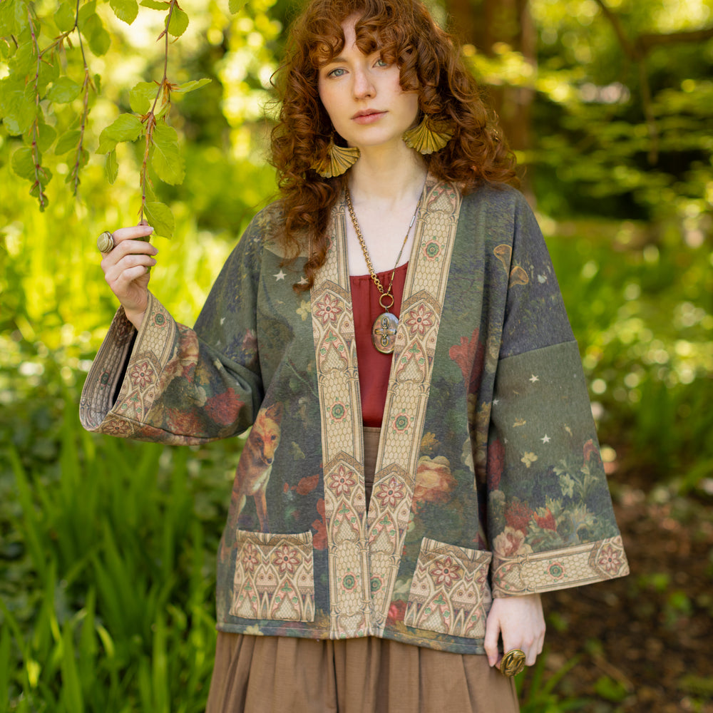 
                  
                    Model wearing a cozy cardigan lined with fleece featuring florals from centuries-old paintings and Rosetti’s iconic portrait of Joan of Arc - Market of Stars
                  
                