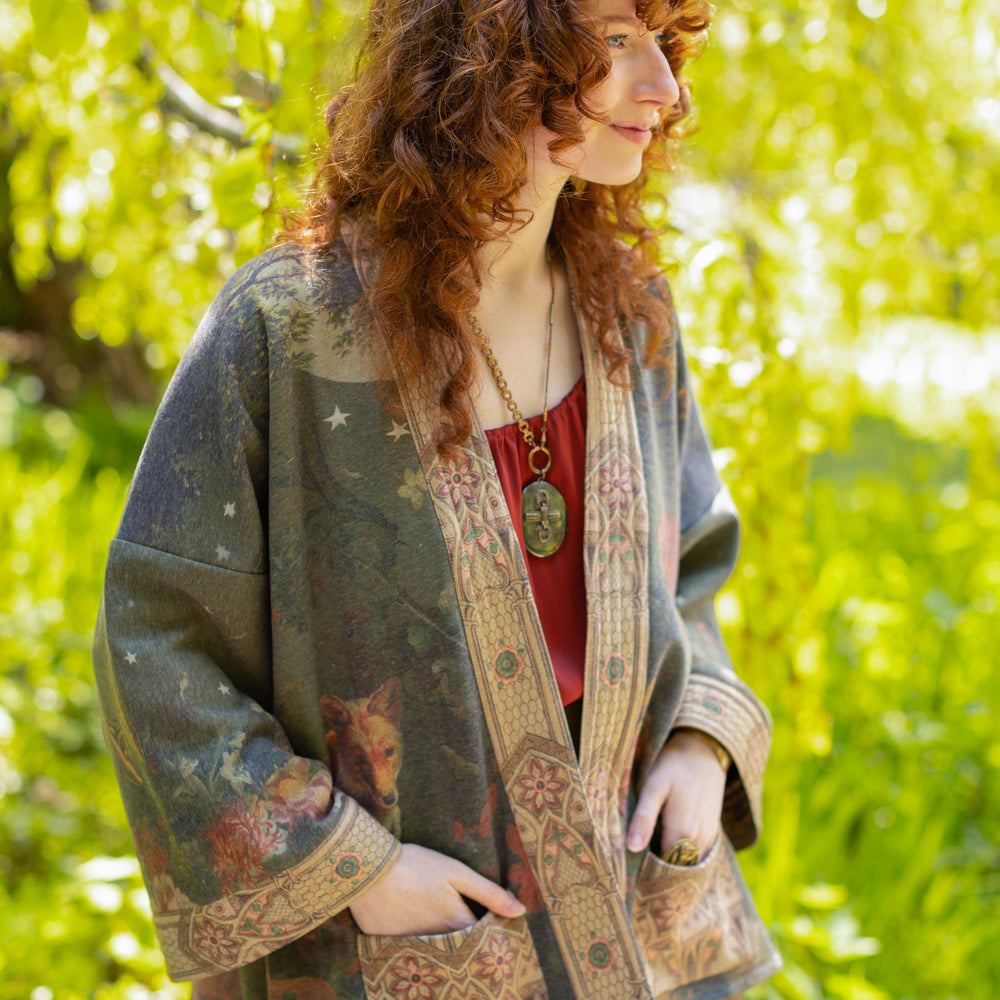 
                  
                    Model wearing a cozy cardigan lined with fleece featuring florals from centuries-old paintings and Rosetti’s iconic portrait of Joan of Arc - Market of Stars
                  
                