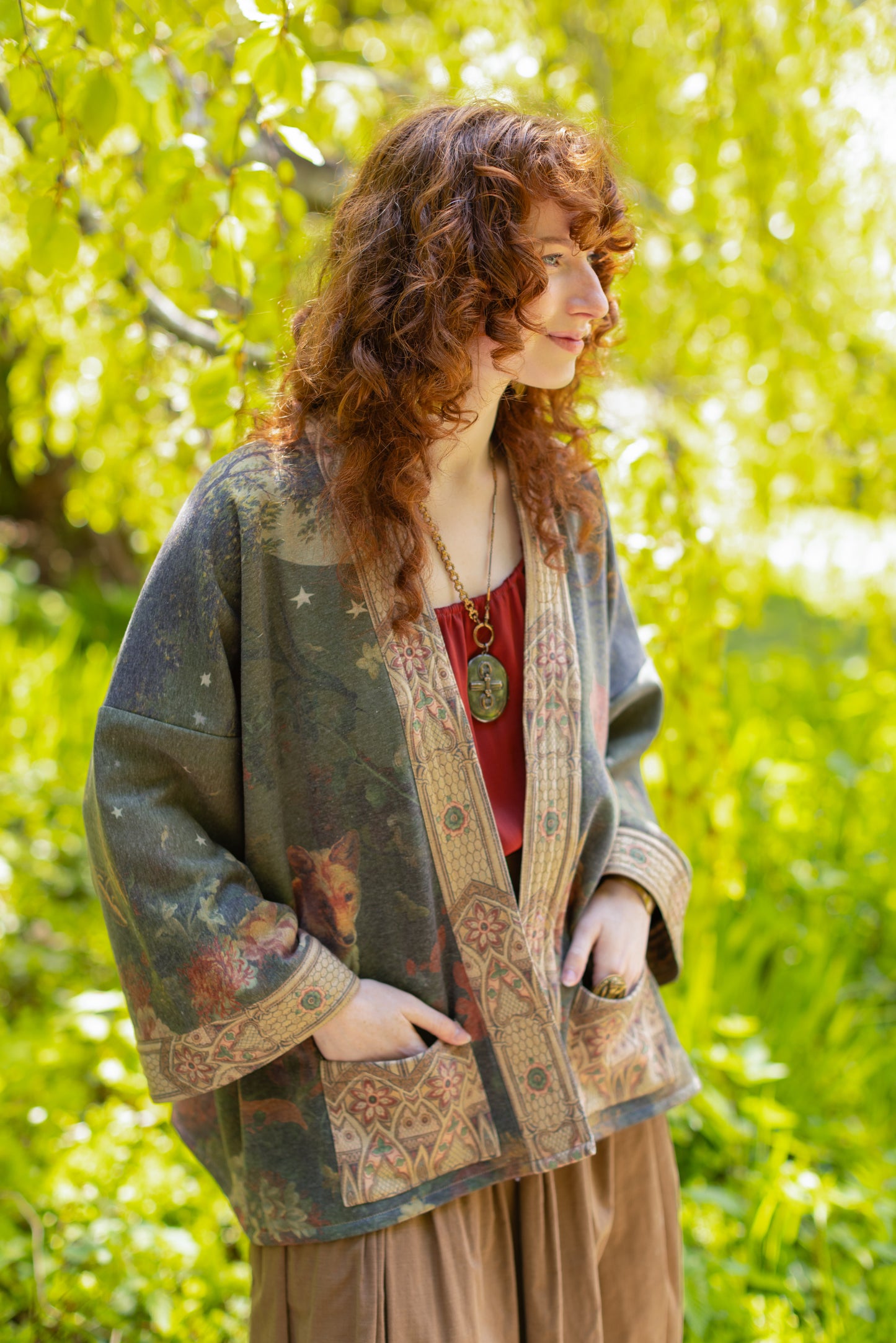 Model wearing a cozy cardigan lined with fleece featuring florals from centuries-old paintings and Rosetti’s iconic portrait of Joan of Arc - Market of Stars