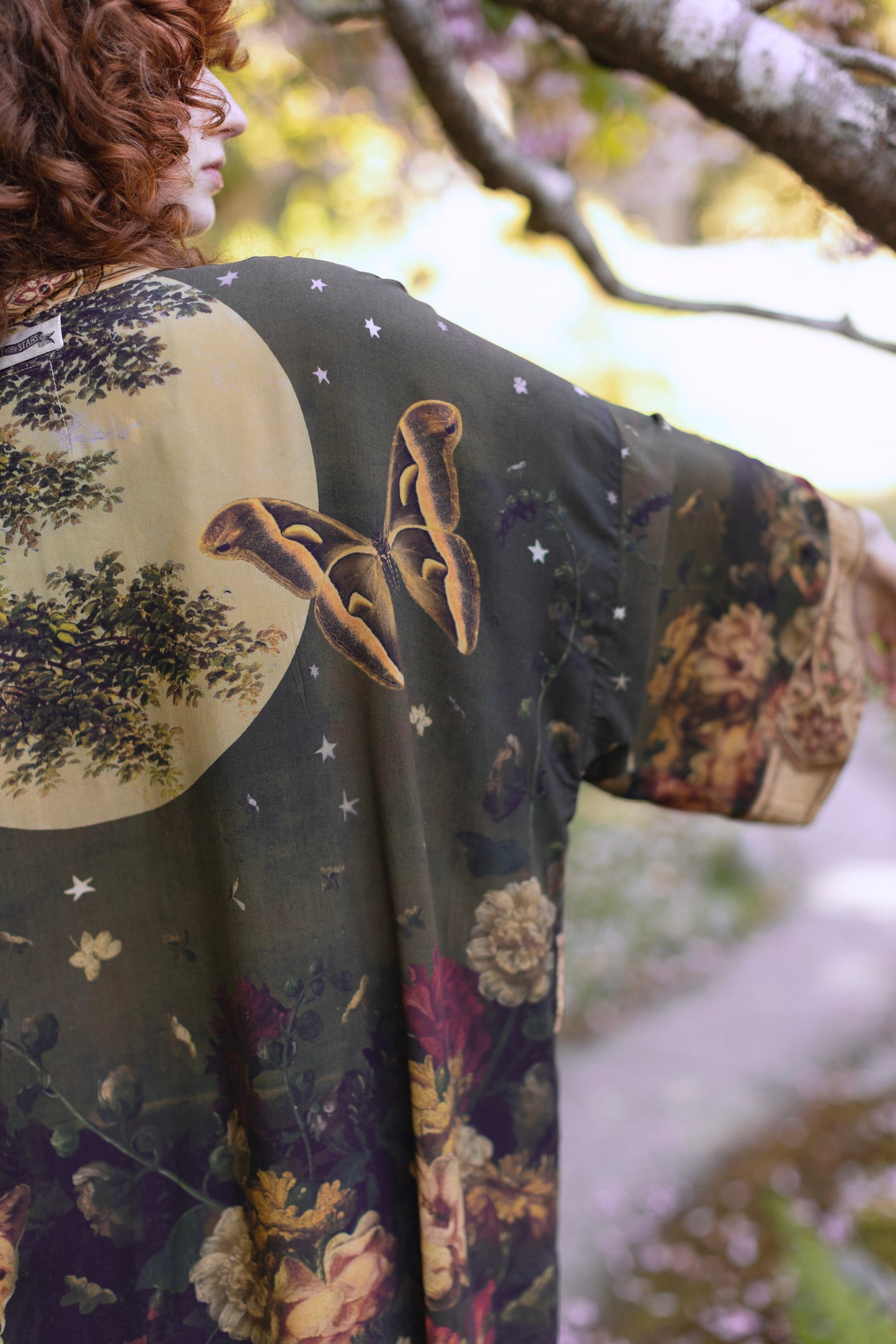 Model wearing a full-length bamboo-viscose duster featuring florals from centuries-old paintings and Rosetti’s iconic portrait of Joan of Arc - Market of Stars