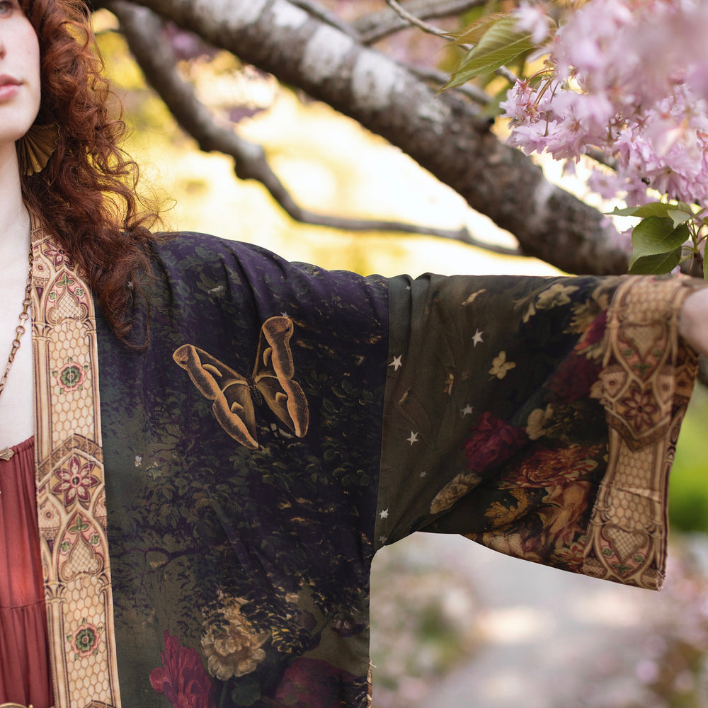 
                  
                    Model wearing a full-length bamboo-viscose duster featuring florals from centuries-old paintings and Rosetti’s iconic portrait of Joan of Arc - Market of Stars
                  
                