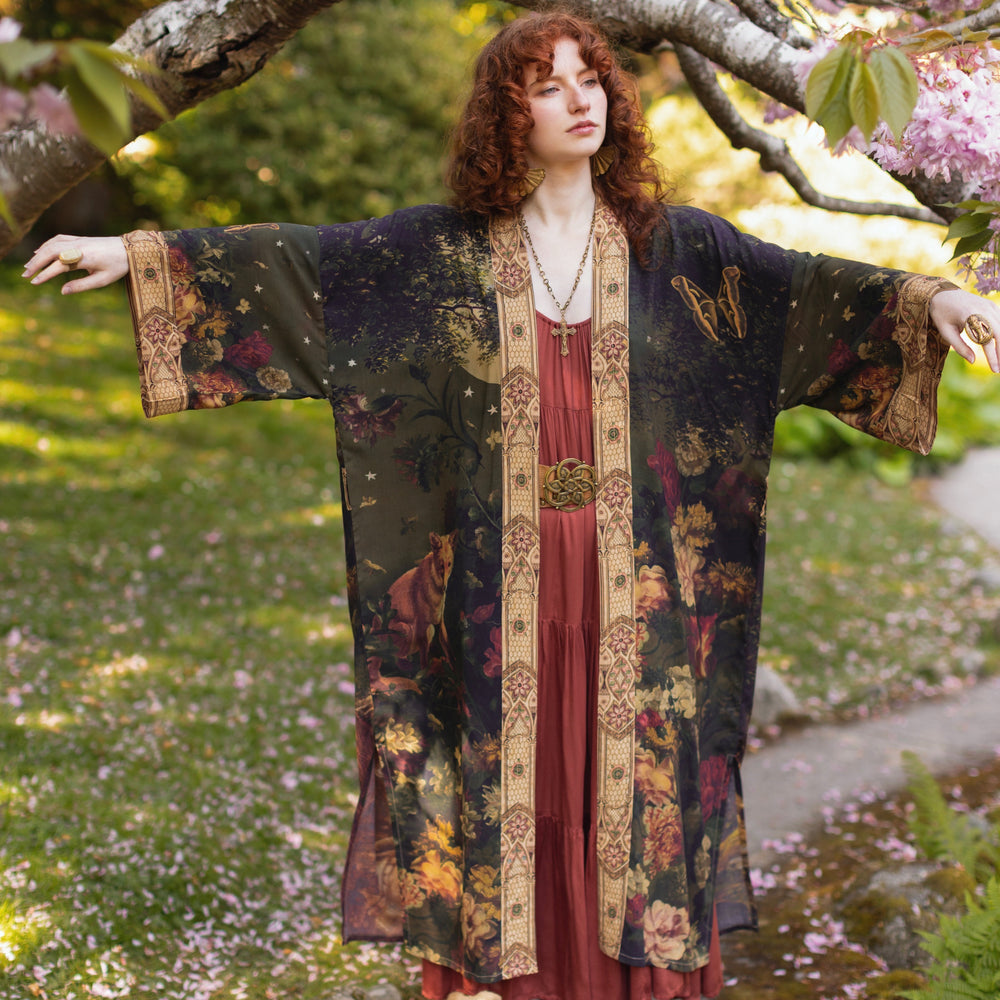 
                  
                    Model wearing a full-length bamboo-viscose duster featuring florals from centuries-old paintings and Rosetti’s iconic portrait of Joan of Arc - Market of Stars
                  
                