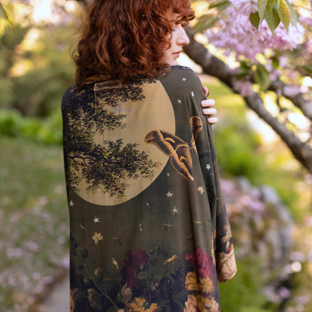 
                  
                    Model wearing a full-length bamboo-viscose duster featuring florals from centuries-old paintings and Rosetti’s iconic portrait of Joan of Arc - Market of Stars
                  
                