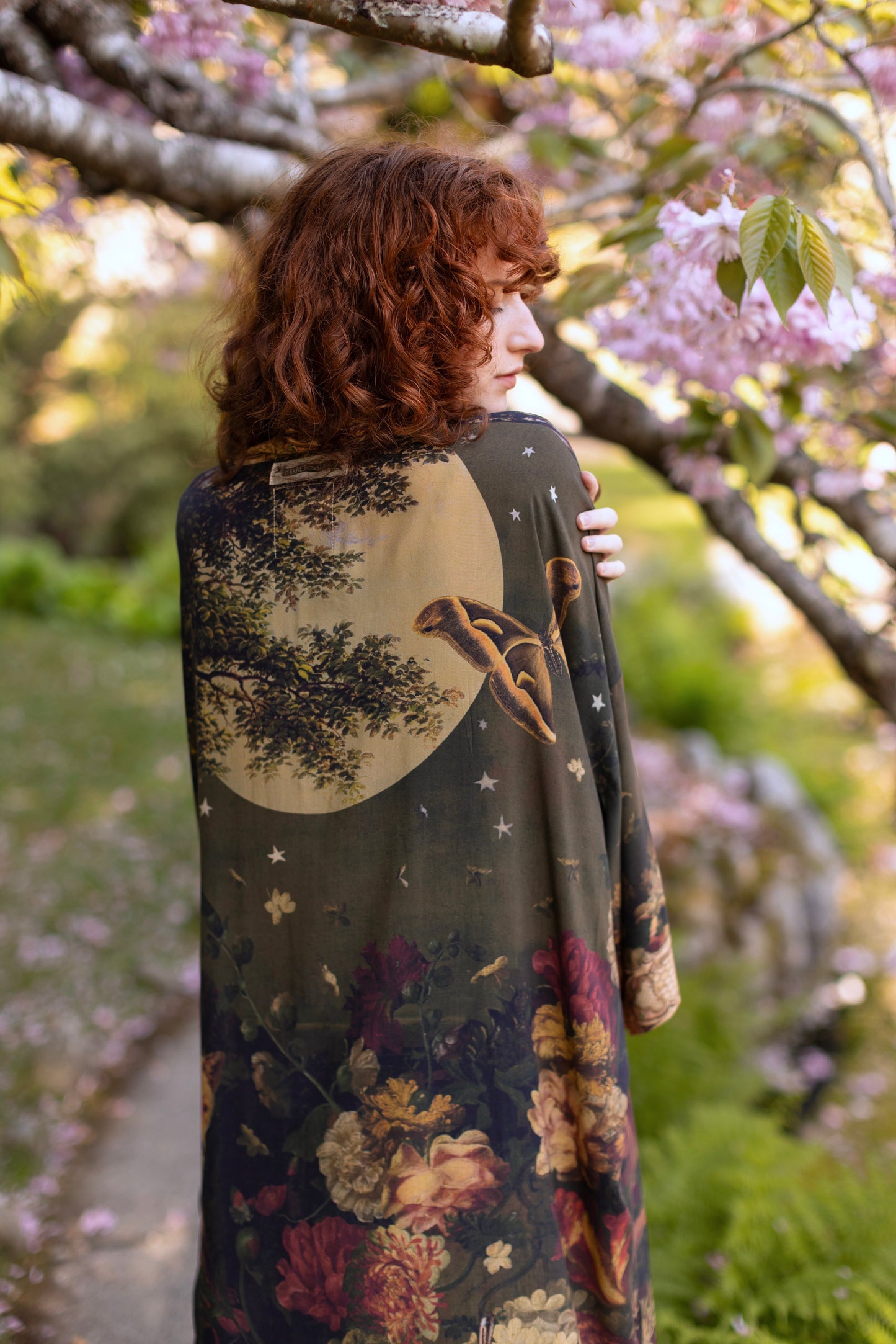 Model wearing a full-length bamboo-viscose duster featuring florals from centuries-old paintings and Rosetti’s iconic portrait of Joan of Arc - Market of Stars