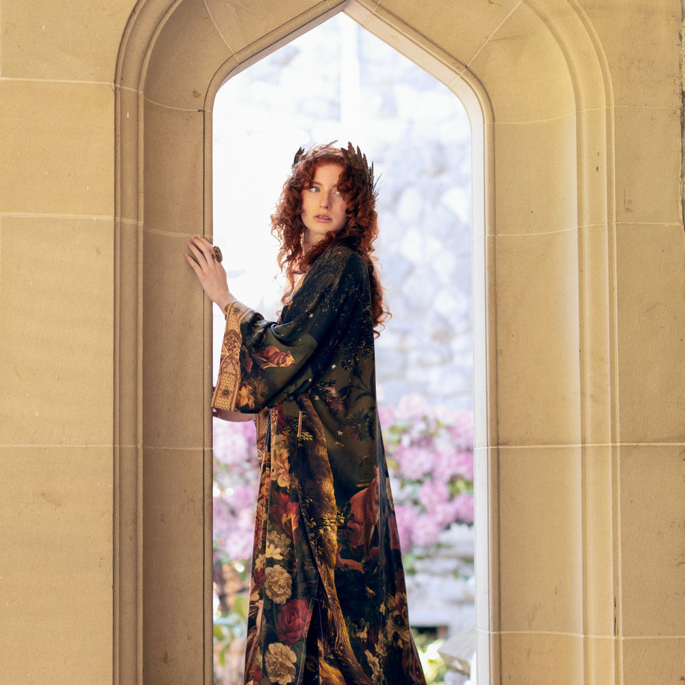 
                  
                    Model wearing a full-length bamboo-viscose duster featuring florals from centuries-old paintings and Rosetti’s iconic portrait of Joan of Arc - Market of Stars
                  
                