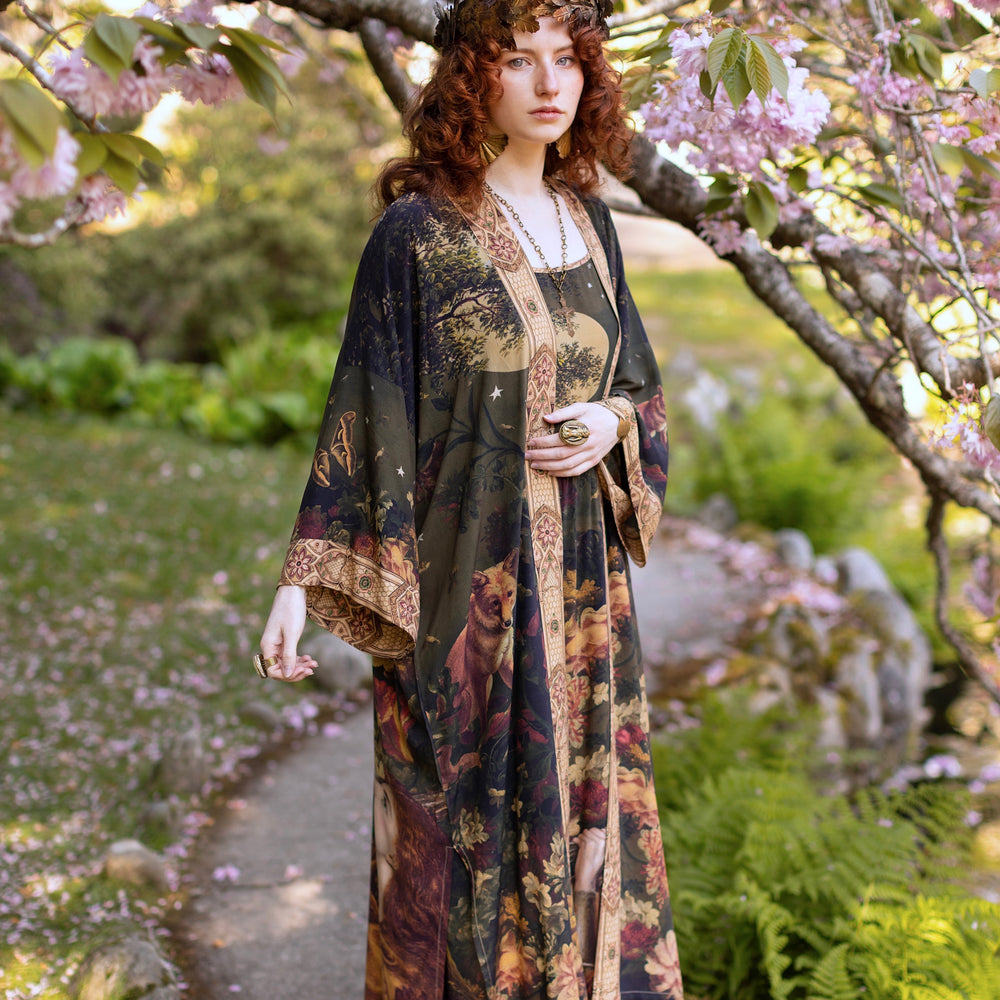 
                  
                    Model wearing a full-length bamboo-viscose duster featuring florals from centuries-old paintings and Rosetti’s iconic portrait of Joan of Arc - Market of Stars
                  
                