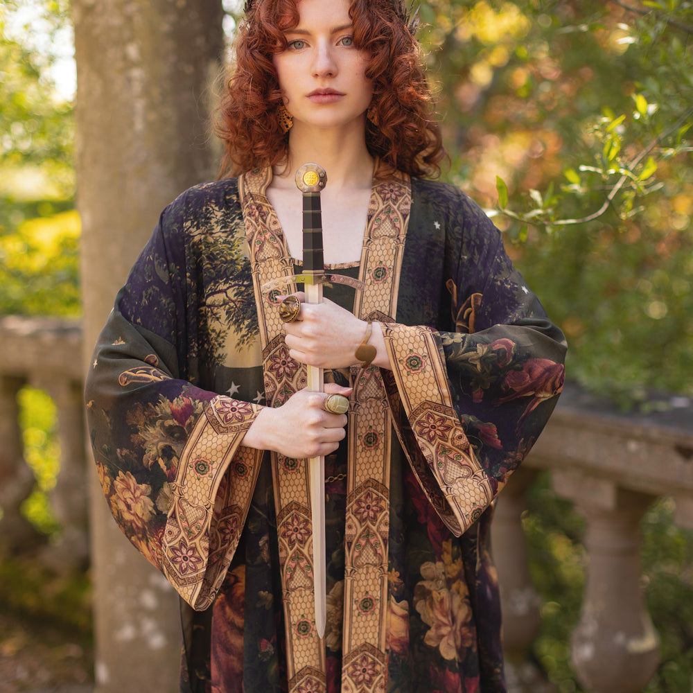 
                  
                    Model wearing a full-length bamboo-viscose duster featuring florals from centuries-old paintings and Rosetti’s iconic portrait of Joan of Arc - Market of Stars
                  
                