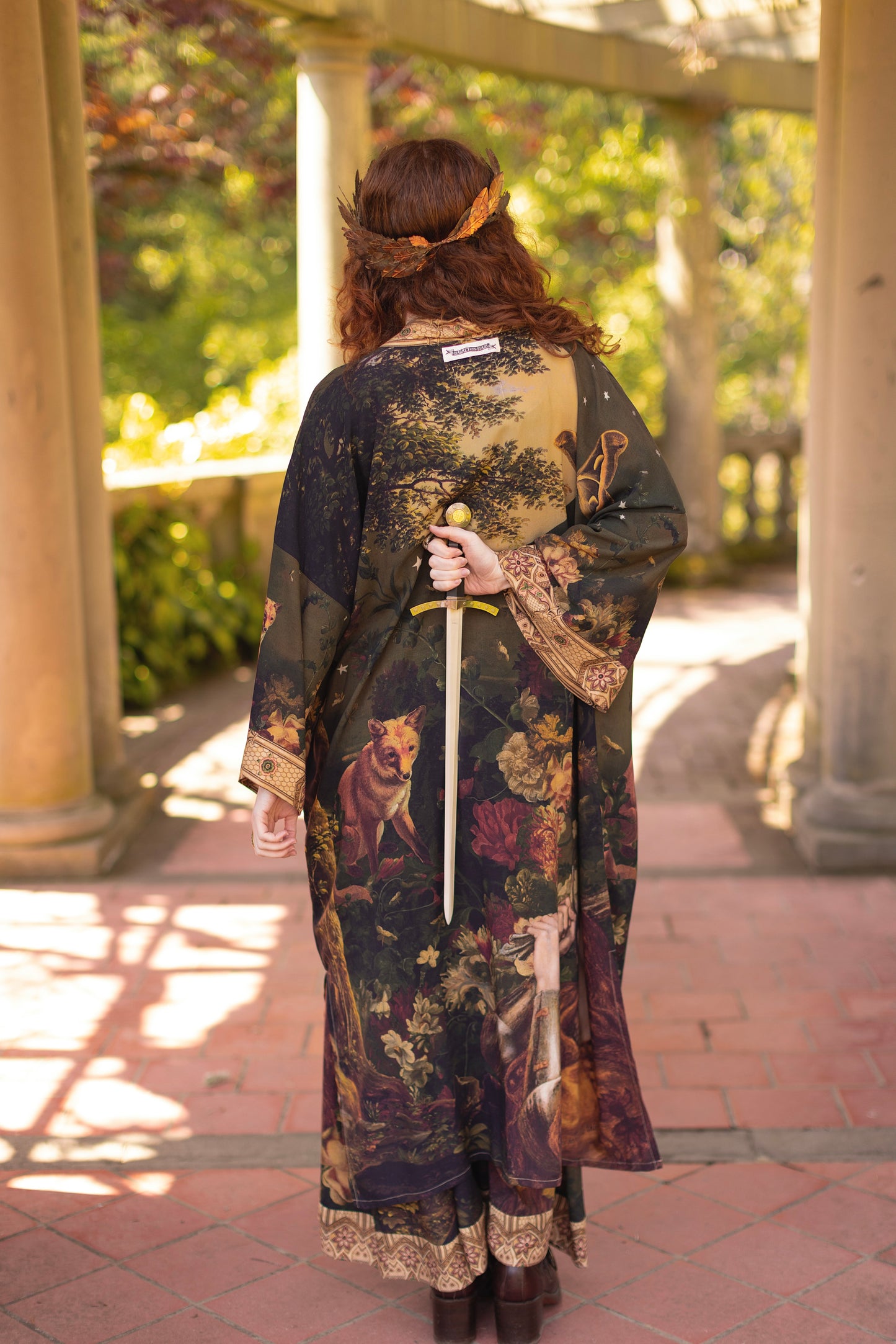 Model wearing a full-length bamboo-viscose duster featuring florals from centuries-old paintings and Rosetti’s iconic portrait of Joan of Arc - Market of Stars