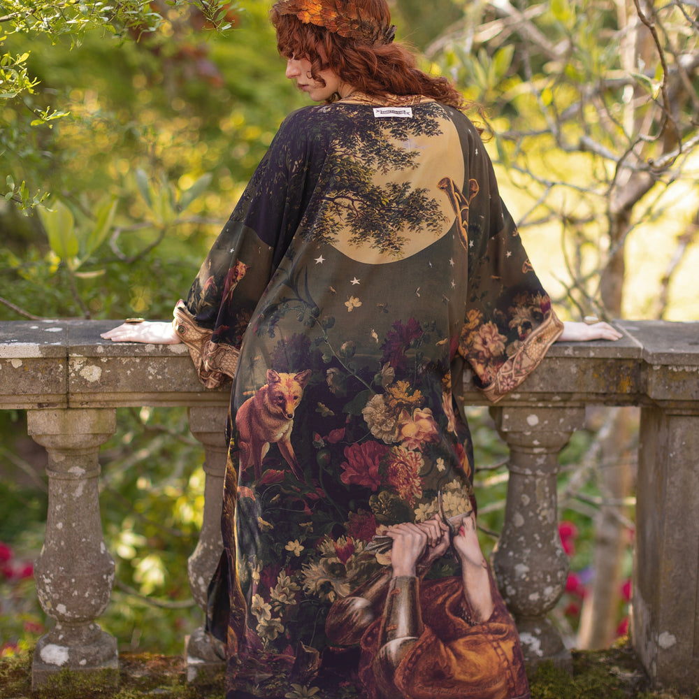 
                  
                    Model wearing a full-length bamboo-viscose duster featuring florals from centuries-old paintings and Rosetti’s iconic portrait of Joan of Arc - Market of Stars
                  
                