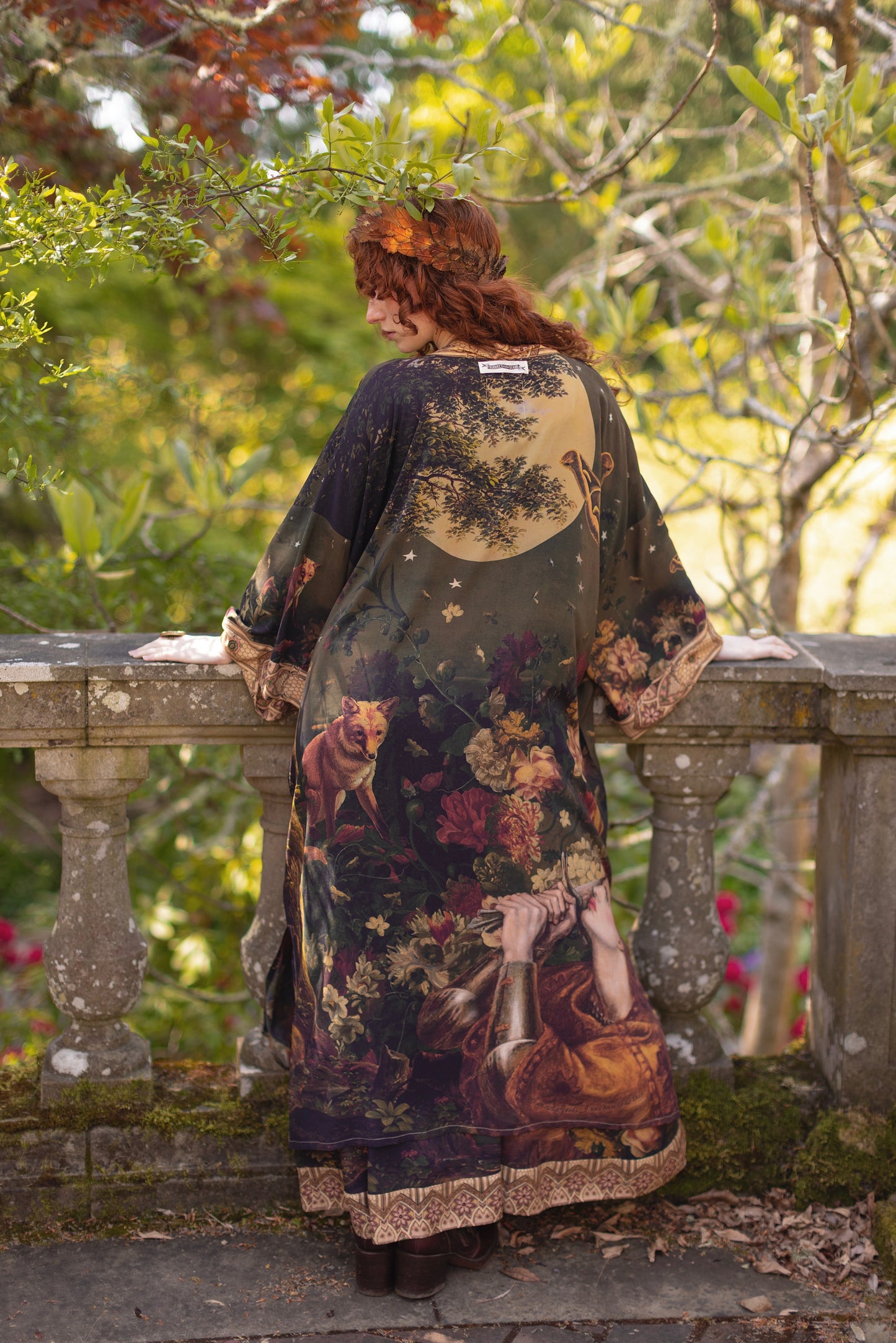 Model wearing a full-length bamboo-viscose duster featuring florals from centuries-old paintings and Rosetti’s iconic portrait of Joan of Arc - Market of Stars