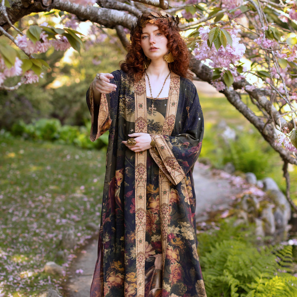 
                  
                    Model wearing a full-length bamboo-viscose duster featuring florals from centuries-old paintings and Rosetti’s iconic portrait of Joan of Arc - Market of Stars
                  
                