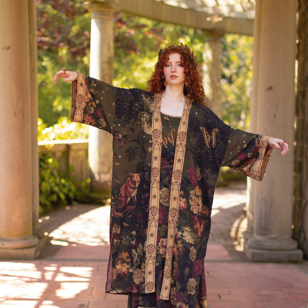 
                  
                    Model wearing a full-length bamboo-viscose duster featuring florals from centuries-old paintings and Rosetti’s iconic portrait of Joan of Arc - Market of Stars
                  
                